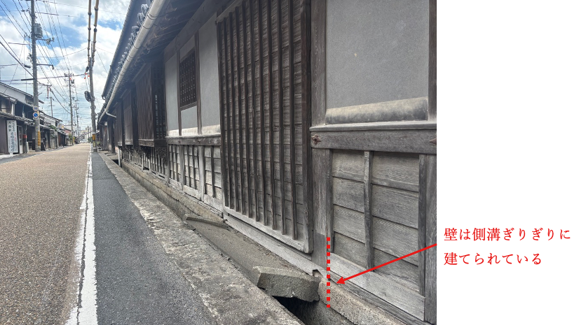 側溝に沿って建てられた旧苅田家住宅の壁